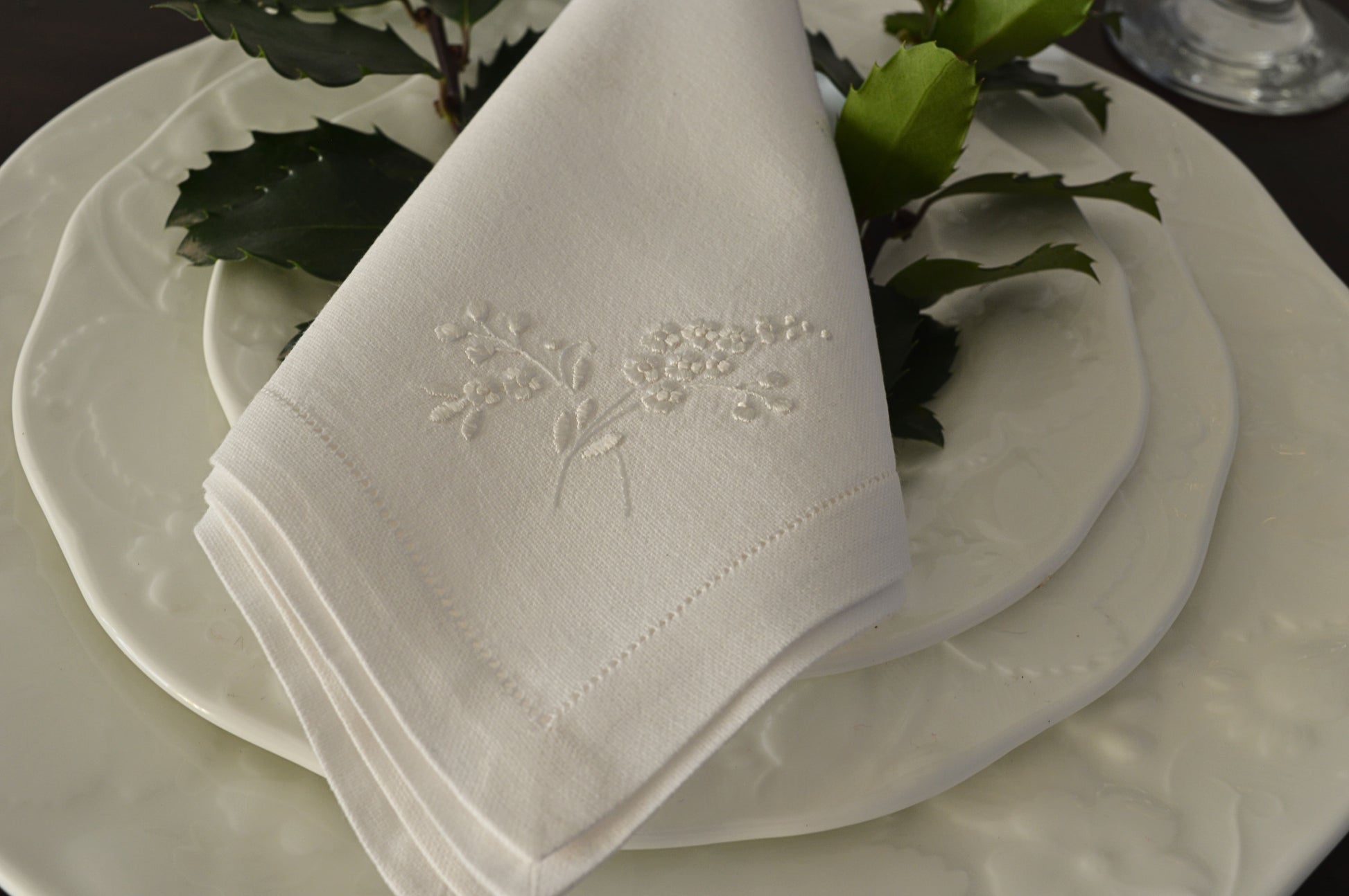 Heirloom dinner napkin with hand embroidered floral stem.